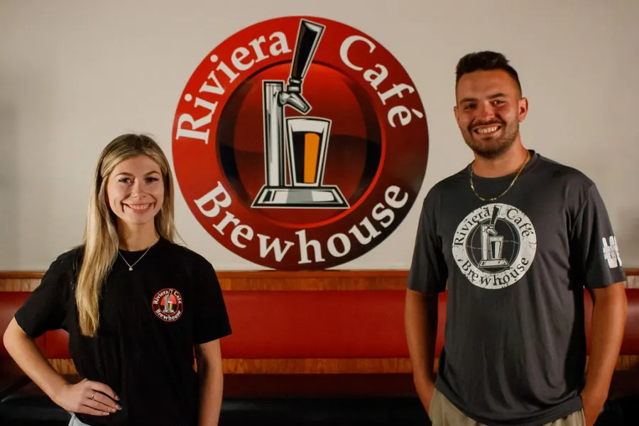 Riviera Cafe Brewhouse staff in front of the Riv logo